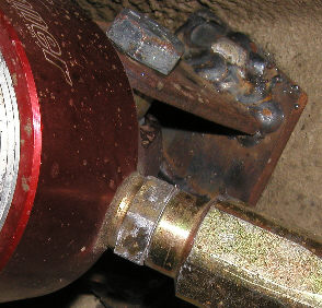 1984 Ford Bronco - Close-up view of a vehicle's suspension system, showing a red component and metal bracket.