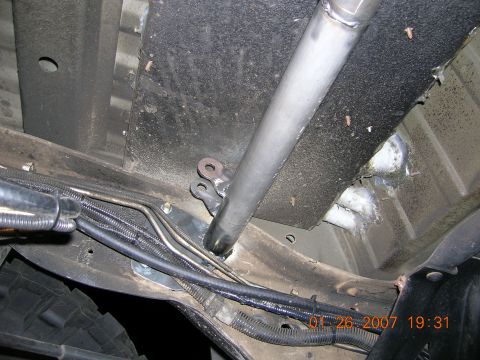1996 Ford Bronco - Close-up view of the underbody of a vehicle, showing structural components and various hoses and wires.