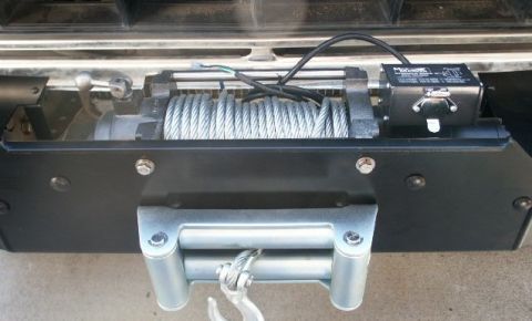 1978 Ford Bronco - Close-up of a winch and roller fairlead assembly, showing the cable and hook.