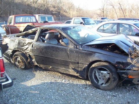1995 Ford Probe - This 1995 Ford Probe shows extensive damage to its rear end, with the roof and body panels compromised.