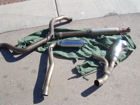 1996 Ford Probe - Exhaust system components, including mufflers and pipes, are displayed on a green tarp.