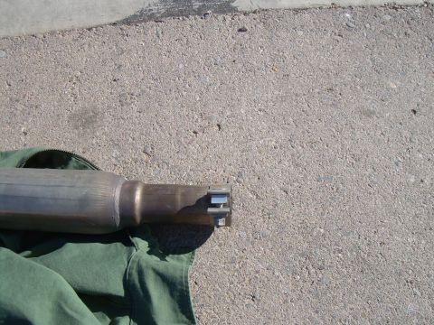 1996 Ford Probe - Close-up view of an exhaust pipe section, resting on green fabric against a concrete background.