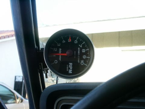 1978 Ford Bronco - A close-up view of a tachometer mounted inside a vehicle, showing the engine's revolutions per minute.
