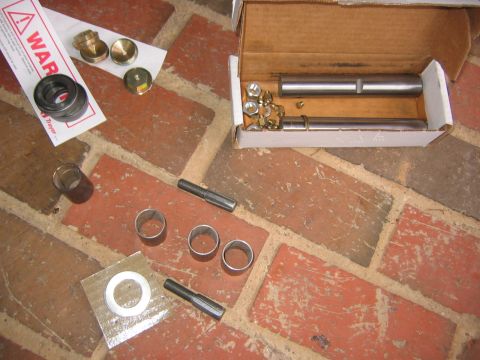 1979 Ford Bronco - Various automotive parts, possibly for a front axle rebuild, are spread across a brick surface.