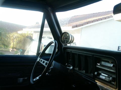 1978 Ford Bronco - View from inside a vehicle, looking towards the dashboard and out the side window.