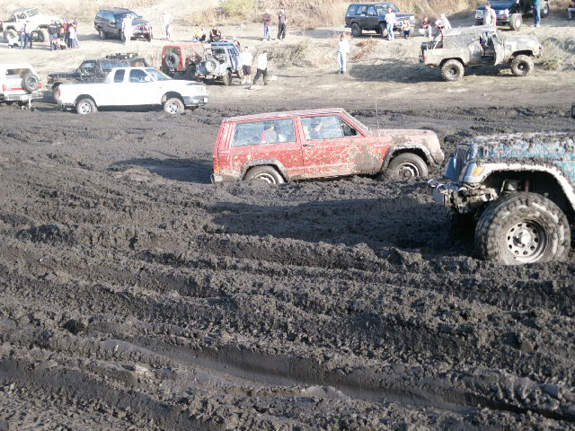 Red SUV stuck in mud, side view