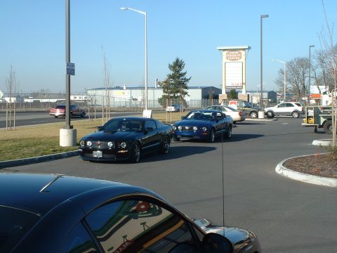 2000 Ford Crown Victoria - Several cars are parked in a lot with a large sign in the background.