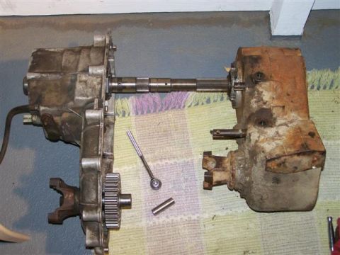1995 Ford Bronco - Disassembled transmission and transfer case components laid out with a driveshaft and tools.