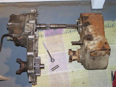 1995 Ford Bronco - Disassembled vehicle drivetrain components are shown on a surface with tools nearby.