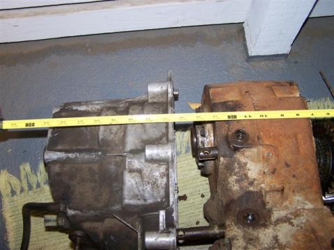 1995 Ford Bronco - Two transmissions are shown side-by-side, with a yellow tape measure indicating their dimensions. One transmission appears cleaner than the…