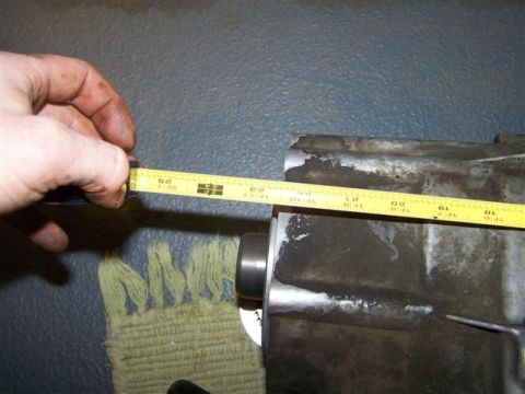 1995 Ford Bronco - Measuring a metal part with a yellow tape measure. The part appears to be dirty and metallic.