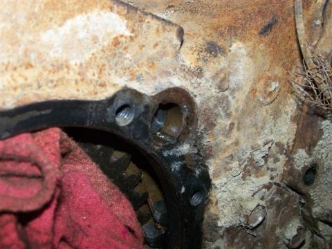 1995 Ford Bronco - Close-up view of a heavily rusted engine component, partially obscured by a red rag, revealing internal gears.