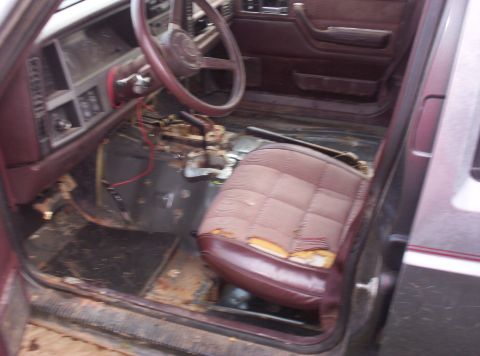 1987 Jeep Cherokee - Interior view of a 1987 Jeep Cherokee with visible wear on the driver's seat and floor.