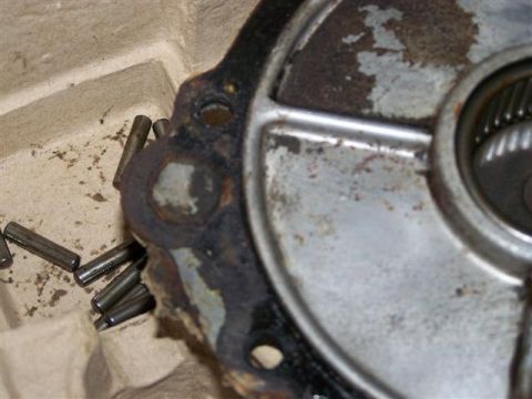 1995 Ford Bronco - A close-up view of metal pins and a component of a gear housing, showing signs of wear and rust.