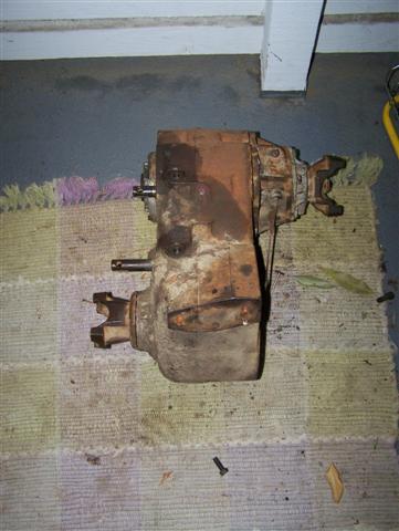 1995 Ford Bronco - Transfer case removed from a vehicle, resting on a rug.
