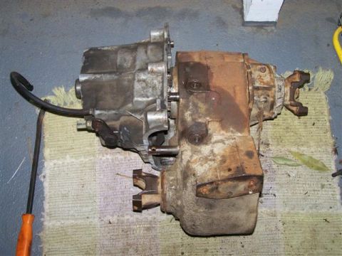 1995 Ford Bronco - Transfer case removed from a vehicle, showing signs of wear and rust.