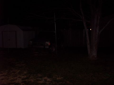 1987 Jeep Cherokee - Front view of a 1987 Jeep Cherokee parked in a yard at night.