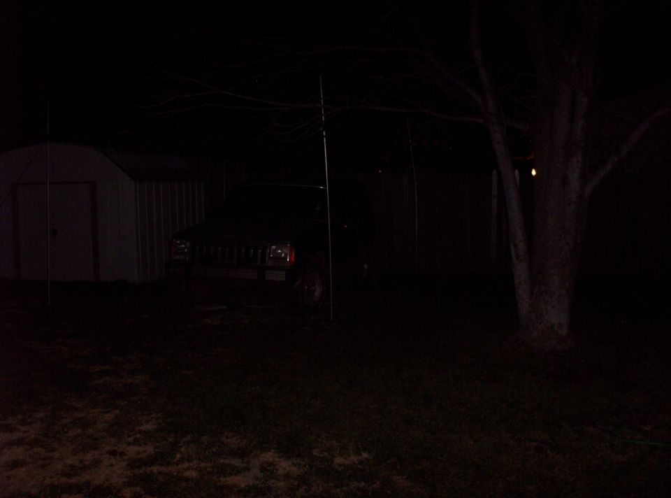 1987 Jeep Cherokee parked at night next to a shed