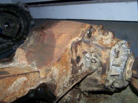1995 Ford Bronco - Close-up of a heavily rusted differential housing, possibly from a Ford Bronco, with visible mesh material.