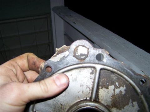 1995 Ford Bronco - Close-up of a damaged metal component being held by a hand.
