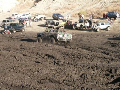 1978 Ford Bronco - A heavily modified 1978 Ford Bronco navigates a challenging off-road course filled with mud and other vehicles.
