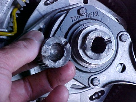 1995 Ford Bronco - A close-up shows a damaged metal component being held by a hand near a larger, complex mechanical assembly.