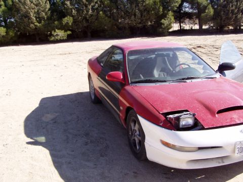 1993 Ford Probe - A red and white 1993 Ford Probe is parked outdoors with its hood open.