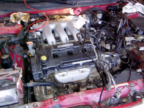 1993 Ford Probe - Engine bay of a Mazda vehicle, likely undergoing an engine swap, with prominent intake manifold and wiring.