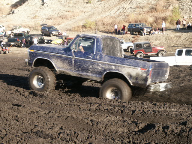 1978 Ford Bronco stuck in deep mud, front wheel turned left