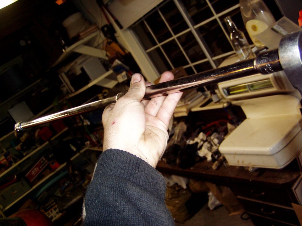 Hand holding a metal rod with a socket attached
