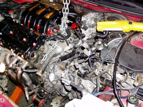 1993 Ford Probe - Engine bay during a swap, with a hoist and work light illuminating the components.