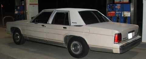 1991 Ford Crown Victoria LTD - Rear three-quarter view of a 1991 Ford Crown Victoria LTD at a gas station.