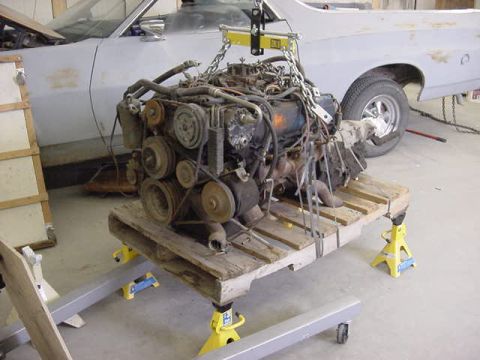 1973 Ford Ranchero - Engine removed from a car and sitting on a wooden pallet supported by jack stands.