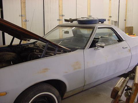 1973 Ford Ranchero - This 1973 Ford Ranchero is shown in a light gray primer with its hood open, revealing the engine bay.