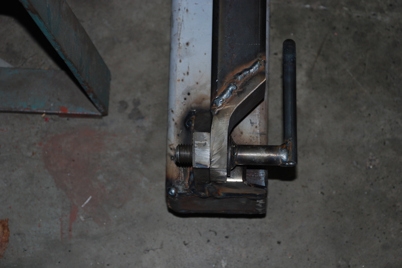 close-up of a metal bracket with a handle, welded together, bolted to a larger metal piece