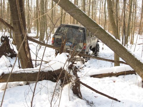 1979 Ford Bronco - Off-road vehicle navigating difficult terrain in a snowy forest.