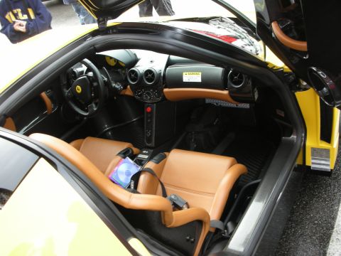 1998 Ford Crown Victoria - Cockpit of a yellow Ferrari Enzo with tan leather seats, carbon trim and a warning label visible on the dash.