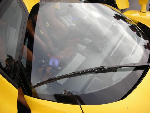 1998 Ford Crown Victoria - View through the windshield of a yellow Ferrari, wiper across the glass, revealing the tan leather interior inside.