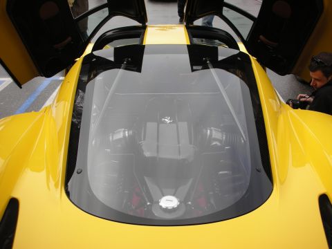 1998 Ford Crown Victoria - Close view through the glass engine cover of a yellow Ferrari, revealing the mid-mounted V engine beneath.