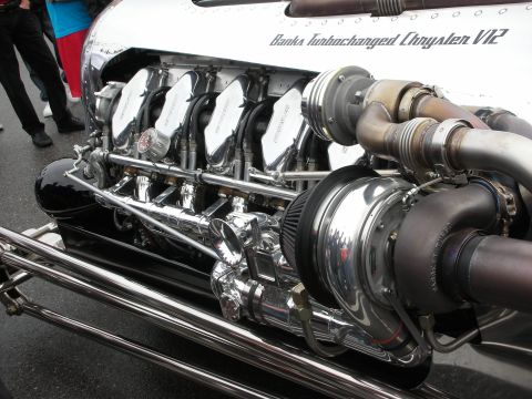1998 Ford Crown Victoria - Side view of a polished Banks Turbocharged Chrysler V12 hot rod engine with chrome turbo and stainless exhaust pipes.