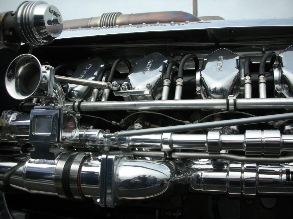 Close-up of a polished chrome supercharged engine with velocity stacks