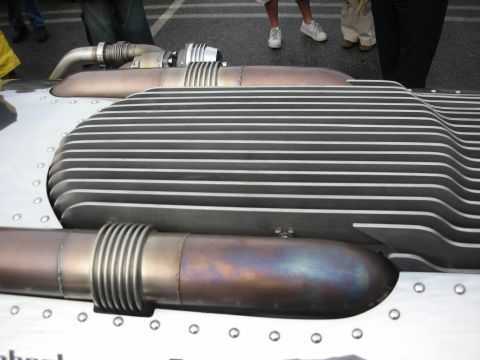 1998 Ford Crown Victoria - large finned aluminum heat exchanger with discolored metal pipes mounted on a riveted panel.
