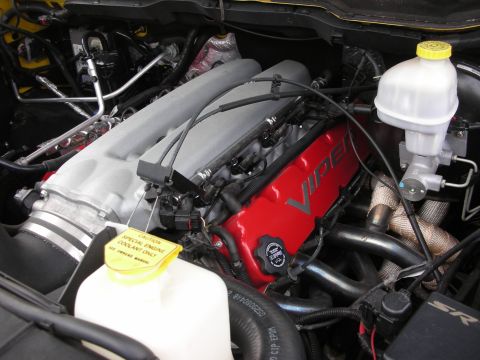 1998 Ford Crown Victoria - engine bay showing a red valve cover marked VIPER alongside fluid reservoirs in a yellow car.