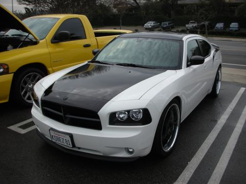 1998 Ford Crown Victoria - white Dodge Charger sedan with a black hood and dark wheels parked next to a yellow pickup.