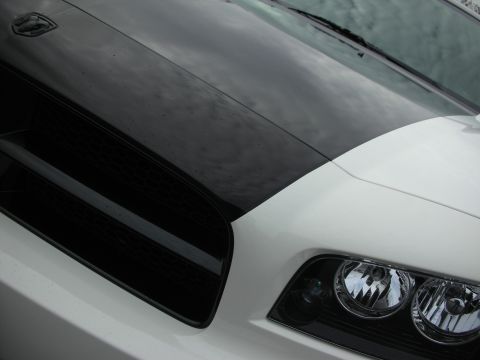 1998 Ford Crown Victoria - Detail of a white Charger's black hood meeting the crosshair grille and a chrome headlight.