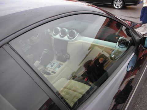 1998 Ford Crown Victoria - Looking through a side window into a tan-leather cockpit with three round dashboard gauge pods.