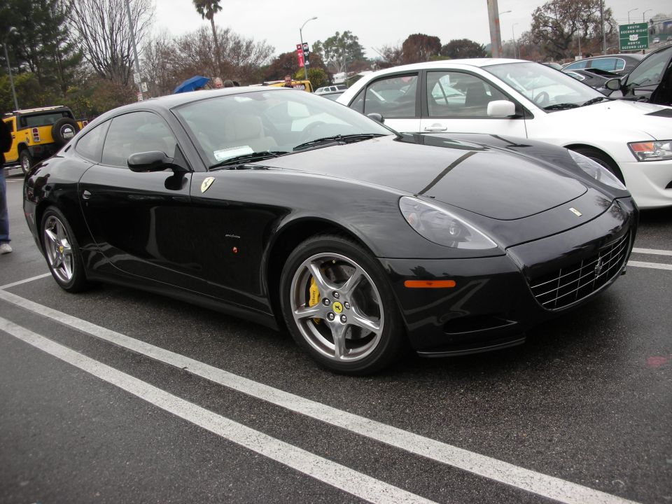 Black Ferrari coupe front three-quarter view in a parking lot