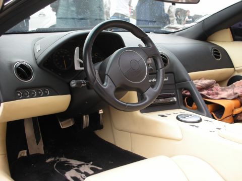 1998 Ford Crown Victoria - Lamborghini cockpit with black steering wheel, tan trim, paddle shifters and a bull-logo mat.