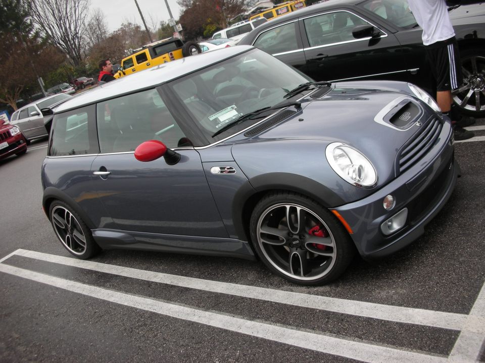 Gray Mini Cooper S with white roof and red mirror cap in a parking lot