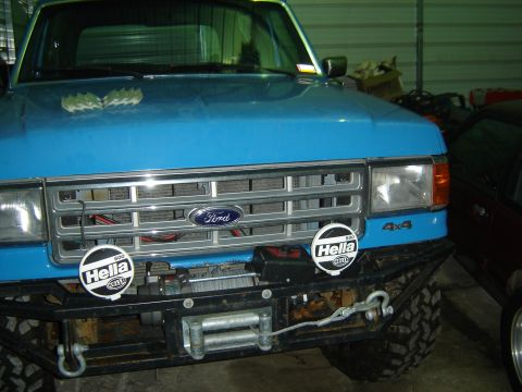 1988 Ford Bronco - This blue Ford truck features a winch and auxiliary lights mounted on a heavy-duty bumper.